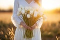 Generative AI International Women& x27;s Day. A woman in a white dress holds a lush bouquet of white tulips at sunset