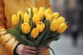 Generative AI International Women's Day. A woman in a yellow raincoat holds a lush bouquet of yellow tulips