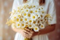 Generative AI International Women& x27;s Day. Young woman in white dress holds a lush bouquet of wild daisies. Close