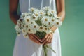 Generative AI International Women& x27;s Day. Young woman in white dress holds a lush bouquet of wild daisies. Close