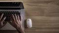 Generative AI Man typing on laptop computer keboard over wood office desk table with white wireless mouse Top view Royalty Free Stock Photo