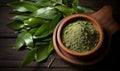 Organic fresh green bay leaves on a wooden board with a bowl of powdered herb, top view Ingredients for cooking or natural herbal