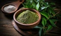 Organic fresh green bay leaves on a wooden board with a bowl of powdered herb, top view Ingredients for cooking or natural herbal