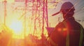 Generative AI technology concept with high voltage power lines electrical engineer helmet digital tablet sunset po Royalty Free Stock Photo
