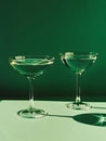 Generative AI. Two Champagne Coupes Casting Shadows on a Green Surface Under Ambient Light Royalty Free Stock Photo