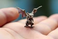 Generative AI, very small, tiny dragon in the hands, very cute and adorable.