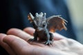 Generative AI, very small, tiny dragon in the hands, very cute and adorable.