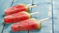 Generative AI Watermelon slice popsicles on a blue rustic wood background business concept. Royalty Free Stock Photo
