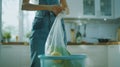 Generative AI Woman placing garbage bag into empty trash bin in kitchen business concept. Royalty Free Stock Photo