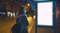 Generative AI Woman standing near blank advertising lightbox on the bus stop mock up business concept.