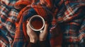Generative AI Womens hands hold a cup of coffee wrapped in scarf on a warm plaid Autumn or Winter concept flat
