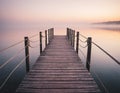 A wooden pier at misty dawn in a still sea Royalty Free Stock Photo