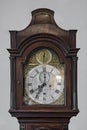 Generic antique old wood and brass grandfather clock face shot straight on that`s no longer manufactured.