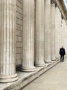 Generic architecture pillars in London and a man walking on the street Royalty Free Stock Photo