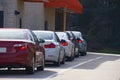 Generic drive thru pickup window with cars waiting in line to get their products or food