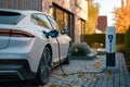 Generic electric vehicle EV hybrid car is being charged from a wallbox