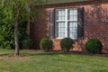 Generic house with red brick, white window with brown shutters Royalty Free Stock Photo