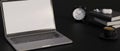 Generic laptop with empty screen, copy space on black table, black background