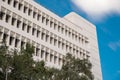 Generic office building structure on a blue sky with trees in foreground Royalty Free Stock Photo