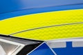 Generic police emergency vehicle car hood reflective light yellow blue white finish stickers full frame object detail up close.
