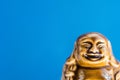 Generic statue of laughing Buddha on sky blue background. Buddhism religious symbol. Zen tranquility harmony concept Royalty Free Stock Photo
