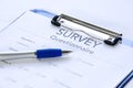 Generic survey questionnaire on clipboard with pen