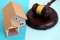 Generic toy house and judgement hammer on blue background Royalty Free Stock Photo