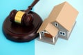 Generic toy house and judgement hammer on blue background Royalty Free Stock Photo