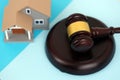 Generic toy house and judgement hammer on blue background Royalty Free Stock Photo
