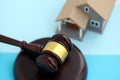 Generic toy house and judgement mallet on blue background Royalty Free Stock Photo