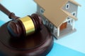 Generic toy house and judgement mallet on blue background Royalty Free Stock Photo