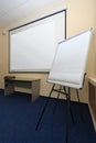 Generic view of blank screen of projector canvas and white board in seminar meeting room Royalty Free Stock Photo