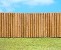 Generic wooden residential privacy fence with green grass yard