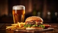 A generous cheeseburger with a pack of fries and a glass of beer. Traditional bar meal.