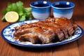 generously coated glazed pork ribs on a blue ceramic plate