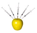 Genetically modified apple and syringes isolated on white background. GMO food concept. Royalty Free Stock Photo