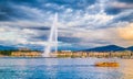 Geneva skyline with famous Jet d`Eau fountain and boat at sunset Royalty Free Stock Photo