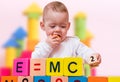 Genius baby with high IQ is playing with cubes and writing formula