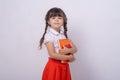 Genius little school child got a bright idea on grey background. Small girl holding book with genius ideas. Royalty Free Stock Photo