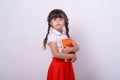 Genius little school child got a bright idea on grey background. Small girl holding book with genius ideas. Royalty Free Stock Photo