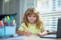 Genius nerd pupil child has idea. Funny child girl doing homework writing and reading at home. Little student at desk in Royalty Free Stock Photo