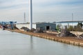 Genk, Limburg, Belgium - Industrial activity and a windmill driven electronic plant at the banks of the Albert canal
