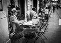 Genoa, Italy - April 21, 2016: Italian men dressed like gentleman reeds the morning newspapers at the outdoor table small cozy ca