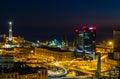 Genoa, Italy, industrial area near the port with Lanterna and commercial skyscrapers at night. Royalty Free Stock Photo