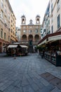 Genoa, Italy: Square with walking people and exterior of the Church of Saint Peter in Banchi (San Pietro in Banchi)