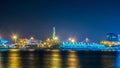 GENOA, ITALY, MARCH 13, 2016: night view of the historical lighthouse in the port of genoa together with sechc cargo Royalty Free Stock Photo