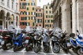 Genoa, Italy, 10/04/2019: Parking of mopeds in the old city against the background of colorful houses