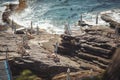 Genoa, Italy - the tourist village of Nervi, marine baths. Beach umbrella and a deck chair on a rocky coastline.