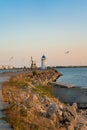 The Genoese lighthouse with a blue roof, on the rocky pier in a port