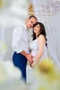 Gentle beautiful pregnant couple near tulle curtains